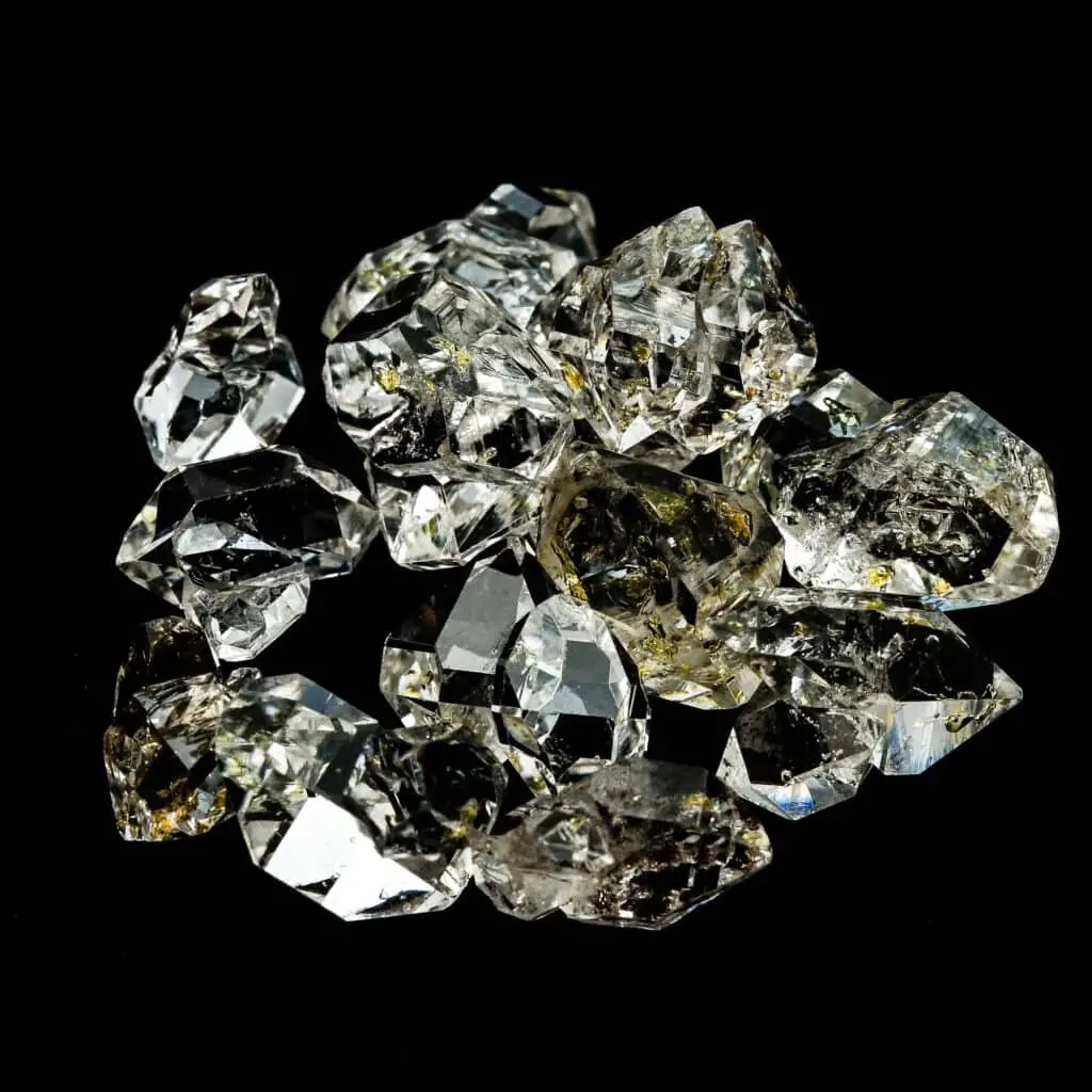herkimer gemstones with oil inside on a black surface